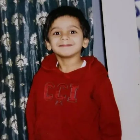 Abdul Samad Siddiqui as a young child, in a red hooded sweatshirt.